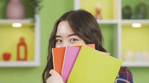Smiling Woman Holding Colorful Books