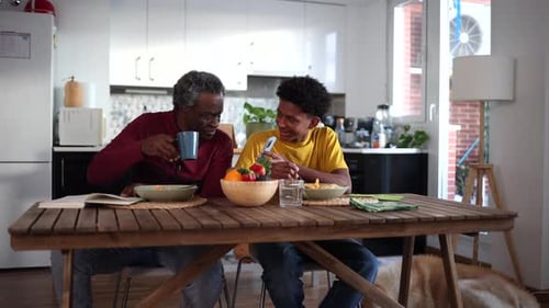 Teen Showing Phone to Adult During Mealtime