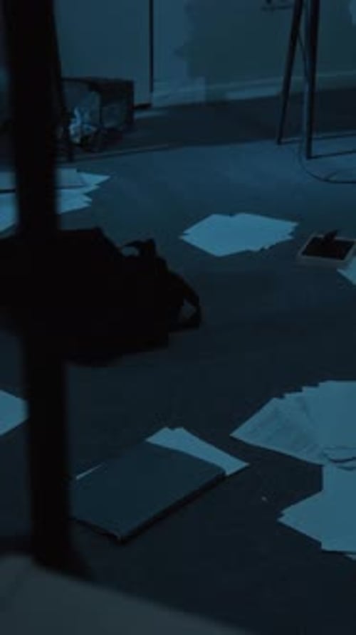 Vertical of Office Floor Strewn with Papers, Notebook, Bag, Overturned Trash Can