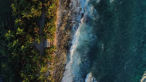 Ocean Coastline with House Ocean Waves and Sunrise or Sunset Tones at Tropical Island Aerial Top