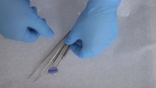 Top-down view of a Professional Dentist preparing his instruments for a patient examination