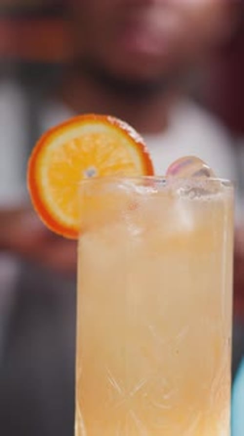 Manicured Hand Garnish Orange Slice on Cocktail