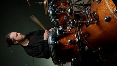 Ein junger männlicher Schlagzeuger spielt ein Schlagzeug in einem Aufnahmestudio bei der Probe eines professionellen Musikers