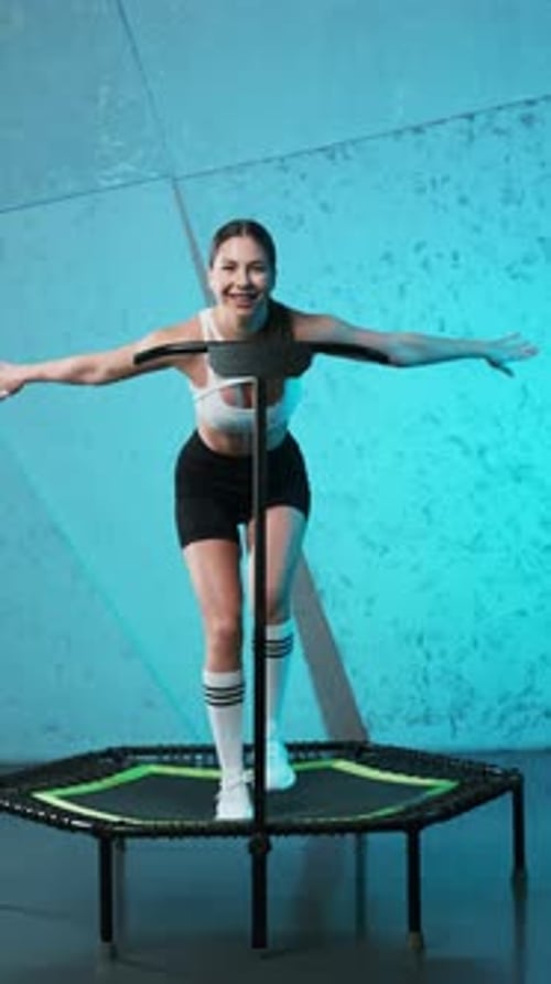 Energetic Woman Bouncing on a Mini Trampoline