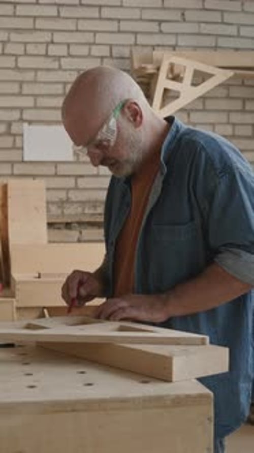 Adult Craftsman Working with Lumber in Workshop