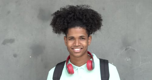 Smiling Young Man with Headphones and Backpack