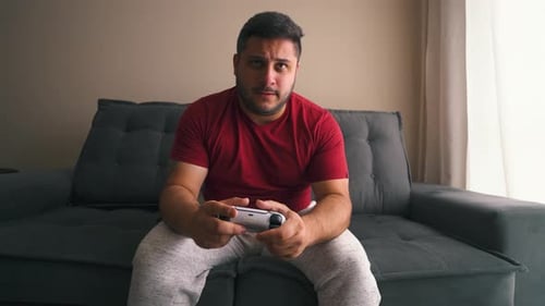 Man Playing Video Games on Couch at Home