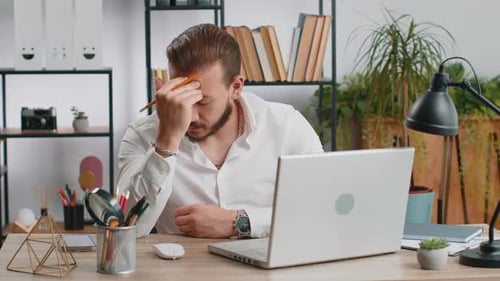Man Working at Desk Gets Tired and Stops