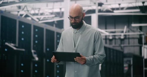 IT Professional Inspecting Racks in Data Center