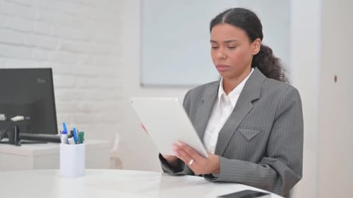 Woman Reads Documents at Desk in Office