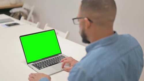 Hispanic Man Using Laptop with Green Screen
