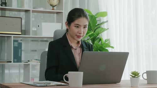 Enthusiastic Businesswoman Working and Typing Laptop in the Office