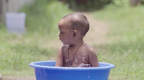 Adorable Infant Splashing Joyfully in Outdoor Bath