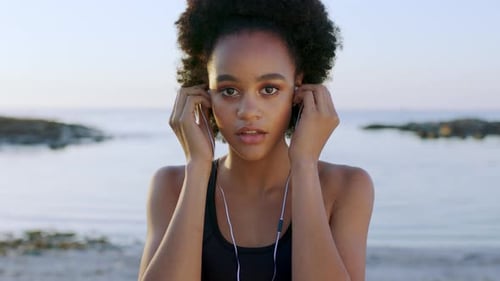 Face, music and beach with a black woman listening to audio while outdoor in nature at sunset