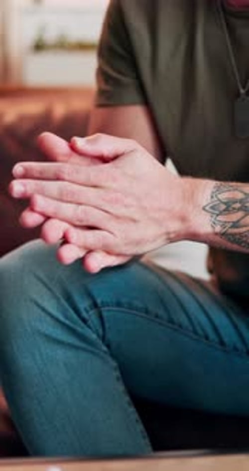 Person rubbing their hands in casual wear indoors