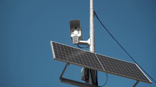 Security Camera with Solar Panel Against Blue Sky