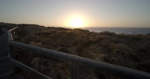 Scenic Beach Sunset Along Wooden Boardwalk