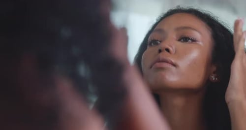 Une jeune femme noire s'inquiétait des rides sur son visage alors qu'elle se tenait devant un miroir.