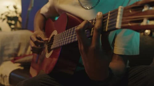 Young Adult Plays Acoustic Guitar at Home