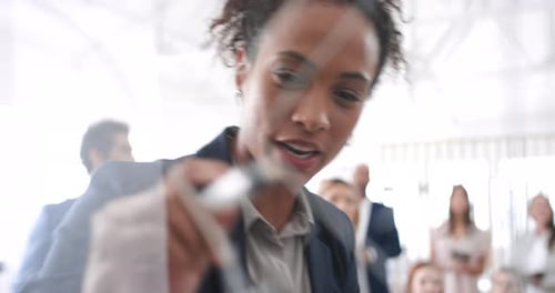 Businesswoman Writing on Clear Board in Modern Office