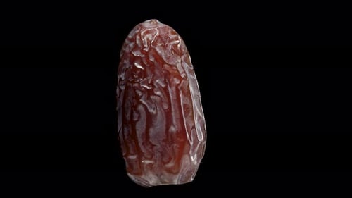 dried date rotates, on a black background close-up. In move