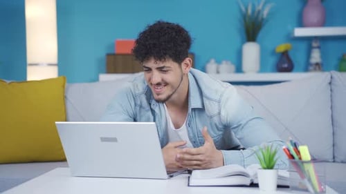 Man Video Conferencing on Laptop at Home