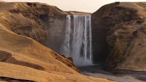 Skógafoss Waterfall, Stunning Icelandic Landscape with Rocky Cliffs and Flowing Water