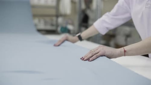A Textile Worker is Delicately Handling Fabric in a Factory Environment with Precision and Care