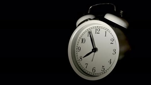 Vidéo en accéléré d'une horloge passant du jour à la nuit sur fond noir.