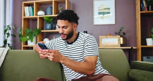 Man Using Smartphone on Couch in Home Living Room