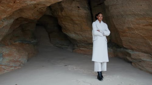Unhappy Girl Thinking Troubles at Seashore Cave. Lonely Woman with Crossed Hands