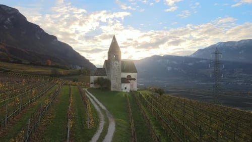 Aerial Drone Over a medieval church in the middle of the Vineyards in Autumn in South Tyrol.