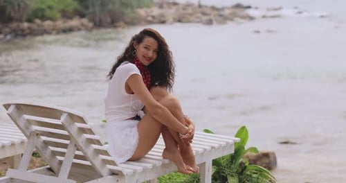 Positive Beach Woman in Summer Stylish Outfit on a Beach Chair During Vacations