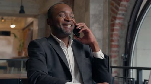 Professional Man Talking on Phone Working at Laptop