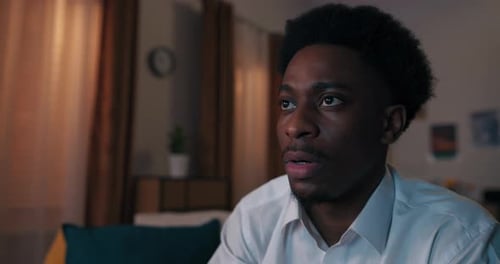 Young Man Watching Something with Interest at Home