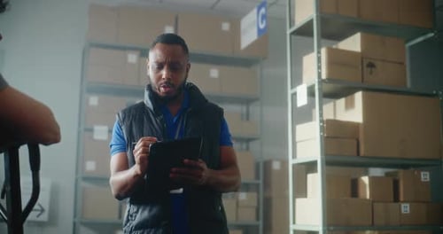 Workers Meeting in Warehouse with Tablet and Boxes