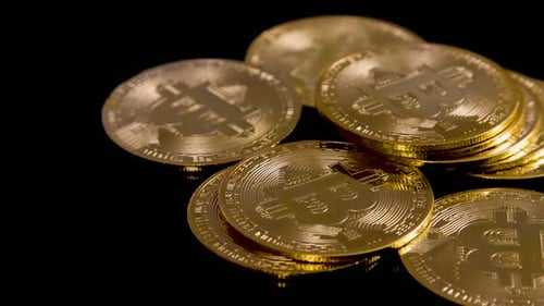 Bitcoins hechos de oro girando sobre fondo, imágenes giratorias en 4K de criptomonedas