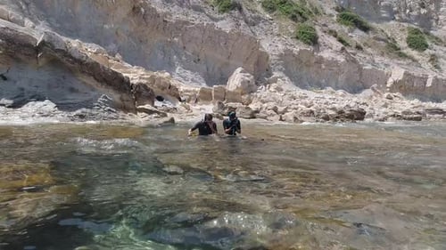 Spearfishers get ready at a rocky shore line in crystal clear waters in the mediterranean sea