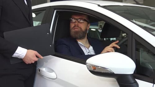 Man Receives Car Keys from Salesman in Dealership