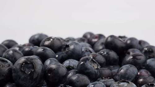 Ripe rotating blueberries on a light background.