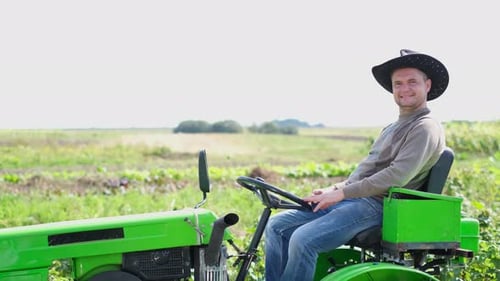 Farmer on a Mini Tractor Driving on the Field Cultivation of Vineyard Plantations