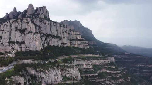 Wide view of Montserrat mountain ridge under cloudy sky in Catalonia, Spain