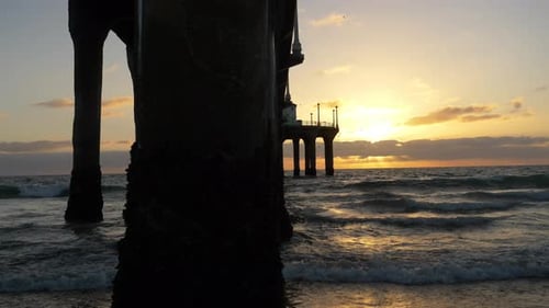 Tracking shot along santa monica beach at golden sunset in California
