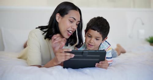 Mother and Son Using Tablet on Bed Together