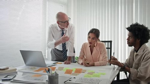 Compañeros de trabajo biétnicos discuten sobre el trabajo en la mesa