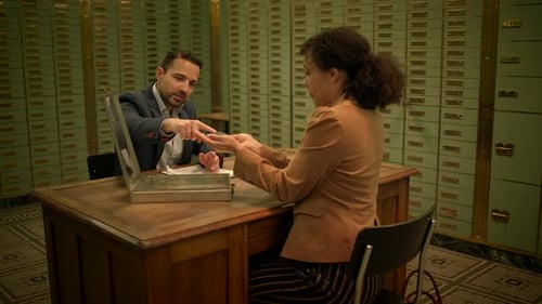 Man and Woman at Desk in Bank Vault
