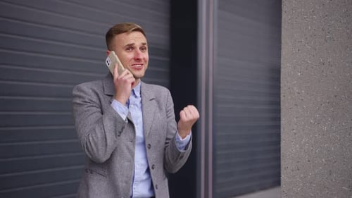 Happy Man Talking on Phone Outside Office Building