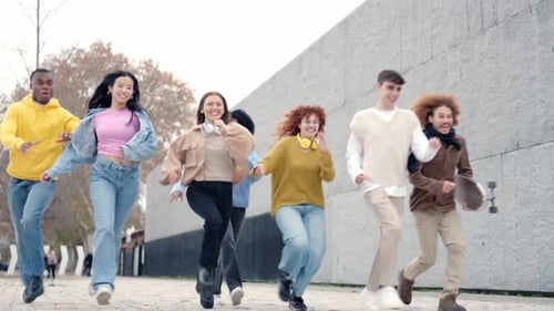 Low Angle View of Diverse Friends Laughing and Running Outdoors
