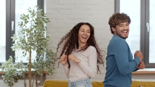 Cheerful couple dancing together at home with joy