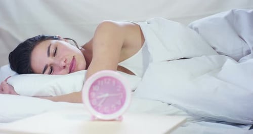 Young Woman Wakes Up and Turns Off Alarm
